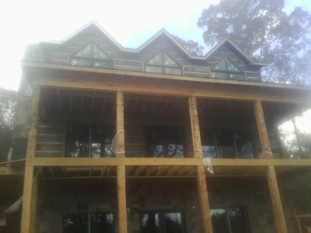 Dormers and porch framing on a large log home under construction — Roof Coating work by our crew in Pataskala