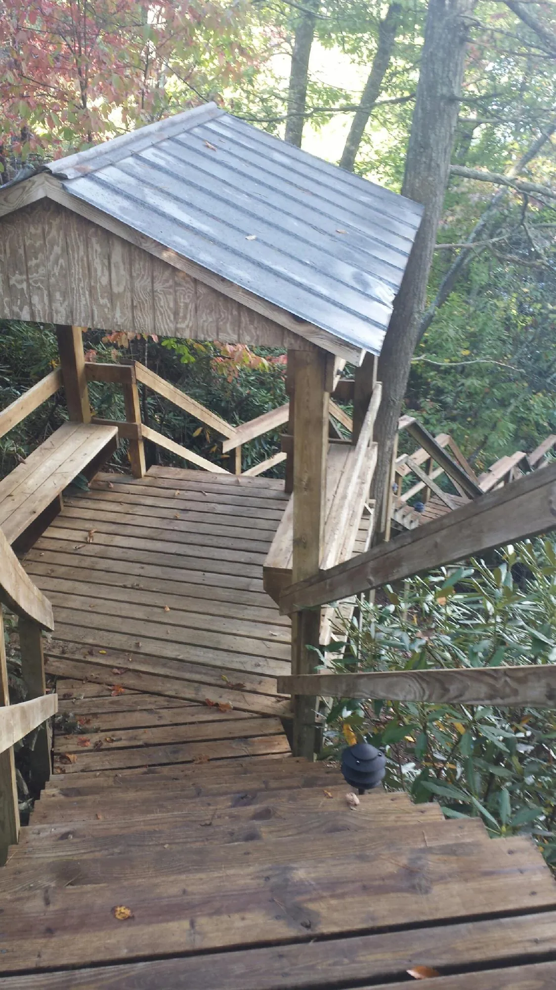 Metal roofed shelter over wooden steps on a wooded walkway — Skylight Repair & Installation work by our crew in Pataskala